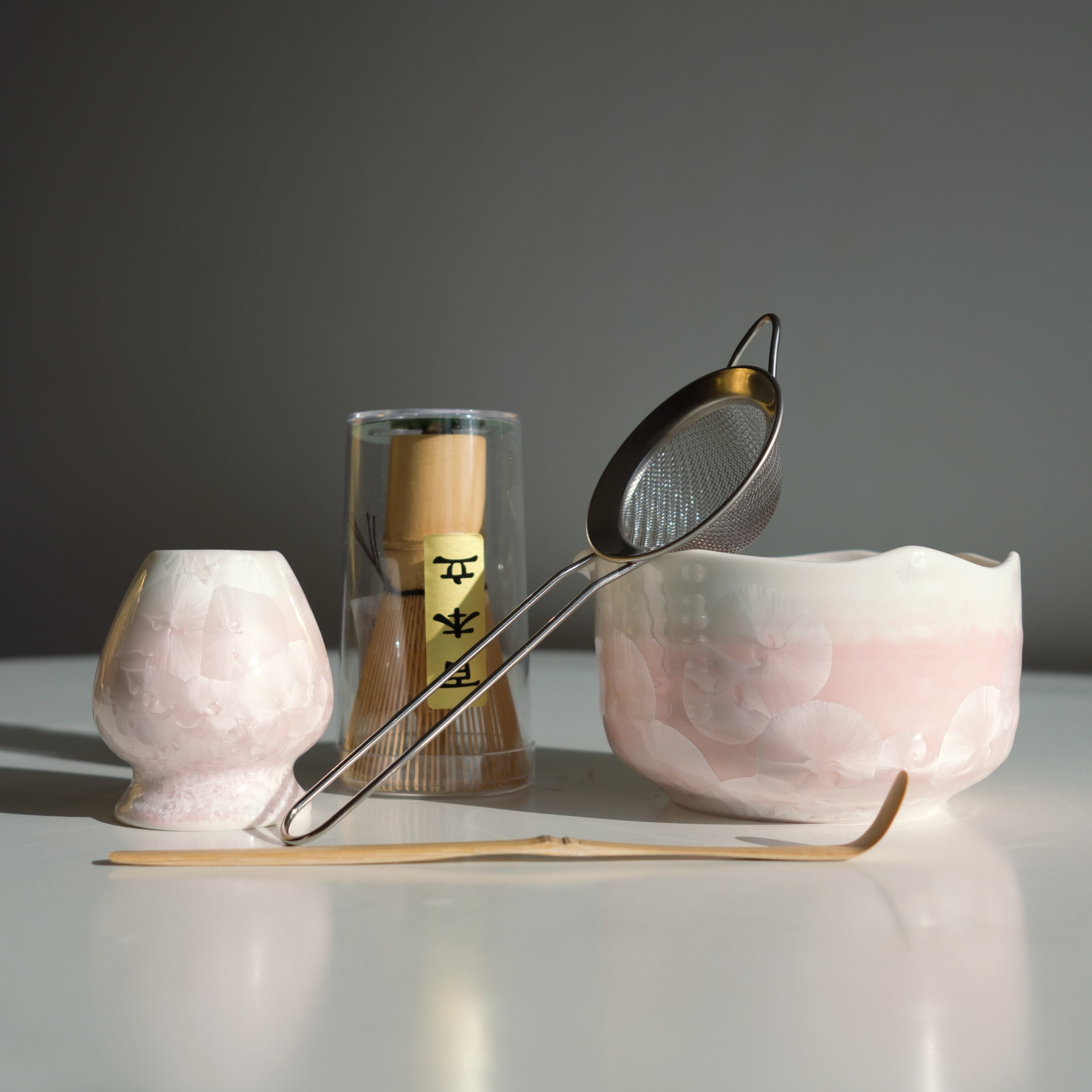 Blush Pink Matcha Set – 5 Piece Japanese Tea Ceremony Kit with front view of the ceramic bowl, metal strainer, bamboo whisk and spoon. 
