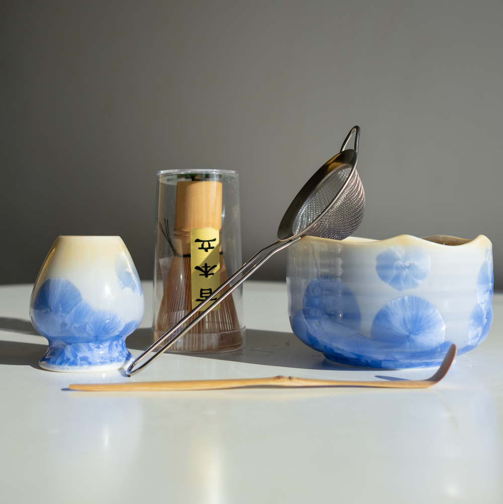 Snow Blue Matcha Set – 5 Piece Japanese Tea Ceremony Kit with front view of the ceramic bowl, metal strainer, bamboo whisk and spoon. 